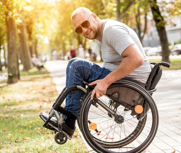 Handicapped man in wheelchair walk at the park alley