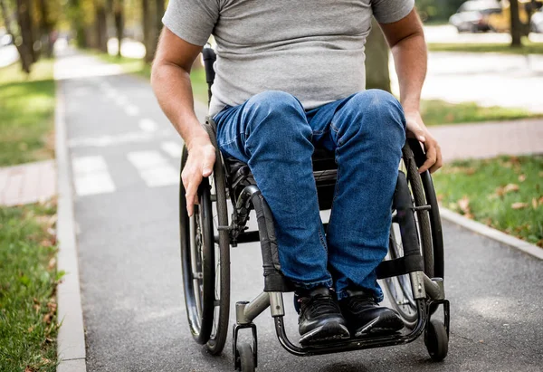 Handicapped man in wheelchair walk at the park alley