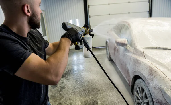 Trabajador de lavado de coches con espuma activa en un lavado de coches. — Foto de Stock