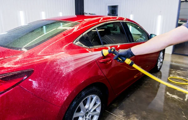 Travailleur de service laver la voiture sur un lavage de voiture. — Photo