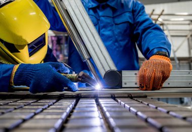 Argon kaynaklı çelik fabrikasında çalışan kaynakçı.