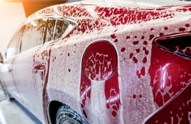Araba yıkama servisinde aktif köpüklü kırmızı araba yıkama.