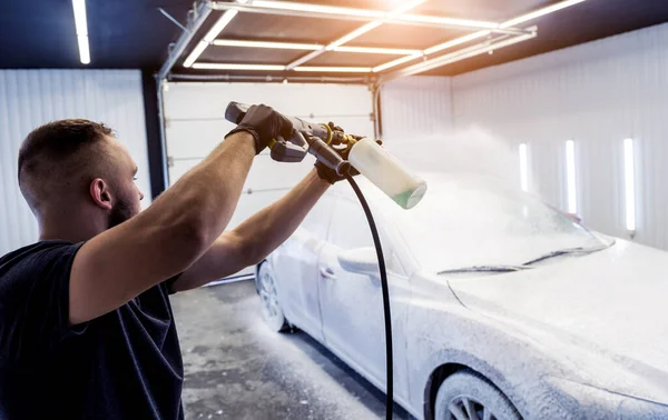 Carro de lavagem de trabalhador com espuma ativa em uma lavagem de carro. — Fotografia de Stock