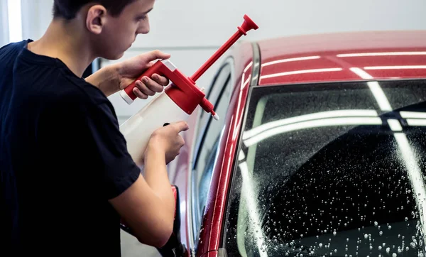 Arbetare tvätta bil med aktivt skum på en biltvätt. — Stockfoto