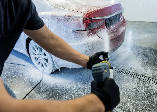 Trabajador de lavado de coches con espuma activa en un lavado de coches. — Foto de Stock