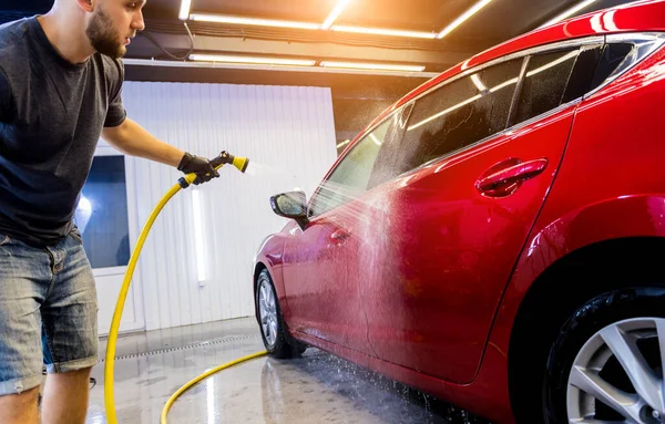 Service medewerker wassen van auto 's op een wasstraat. — Stockfoto