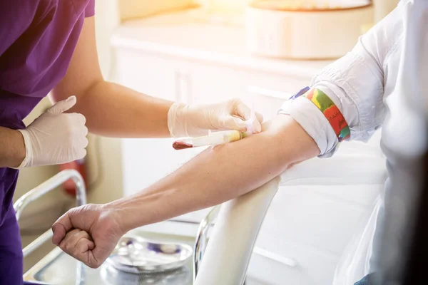 Медсестра приймає зразки крові пацієнтів у лабораторії — стокове фото