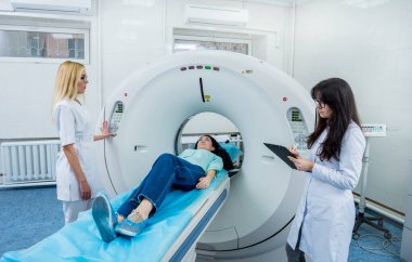 Doktorlar ve hasta hastanedeki bilgisayarlı tomografi odasında.
