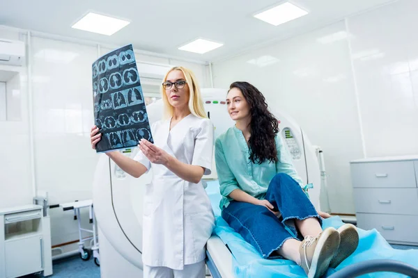 Radiologista com uma paciente examinando uma tomografia computadorizada — Fotografia de Stock