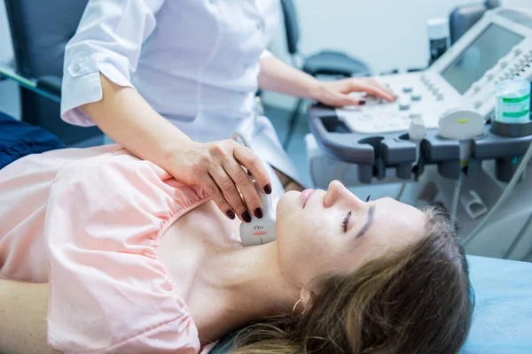 Medico che utilizza la macchina di scansione a ultrasuoni per esaminare una tiroide della donna — Foto Stock