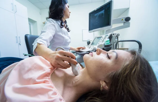 Médico usando máquina de exploración por ultrasonido para examinar una tiroides de la mujer — Foto de Stock