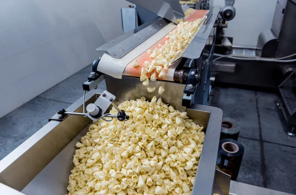 現代の工場で軽食やチップを梱包するためのコンベアライン — ストック写真