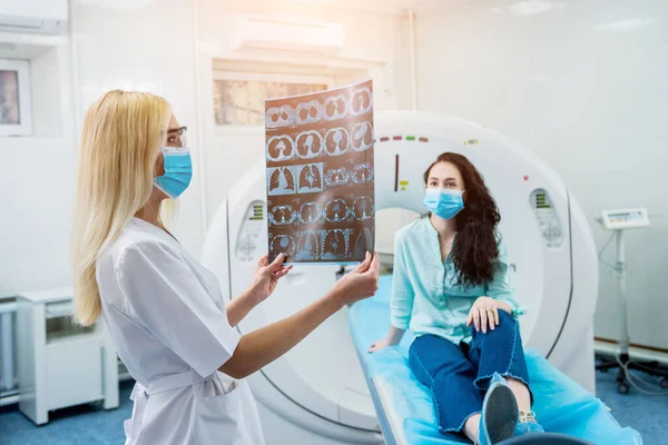 Radiologe mit einer Patientin mit Schutzmasken bei der Untersuchung eines CT-Scans — Stockfoto