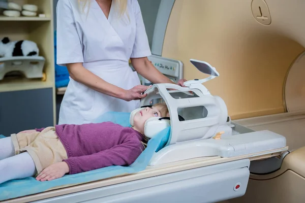 Radiologista prepara a menina para um exame cerebral MRI — Fotografia de Stock