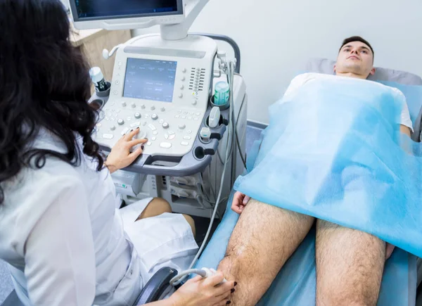 Läkare med ultraljud skanningsmaskin undersöka skadade knä — Stockfoto