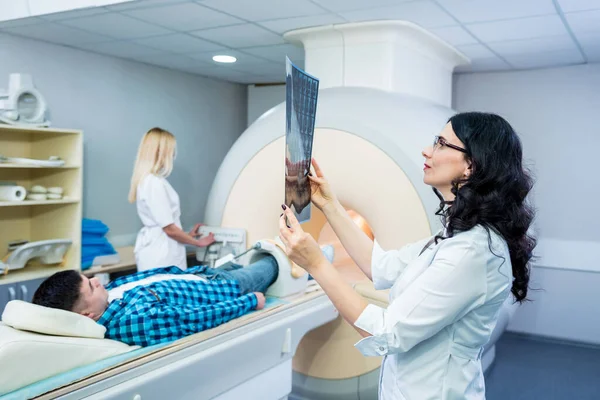 Radiologe mit einem männlichen Patienten bei der Untersuchung eines MRI-Scans — Stockfoto