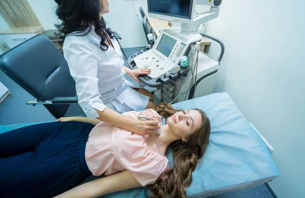 Médico usando máquina de exploración por ultrasonido para examinar una tiroides de la mujer — Foto de Stock