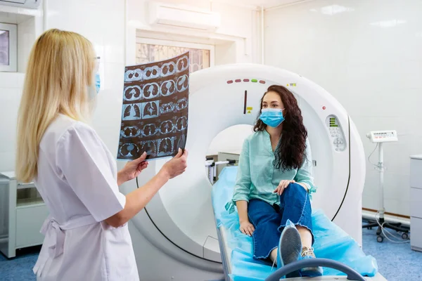 Radiológus egy női beteggel, aki védőmaszkot visel, és CT-vizsgálatot végez. — Stock Fotó