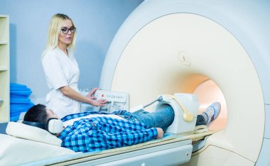 Radyoloji uzmanı hastayı MRI diz muayenesi için hazırlıyor.