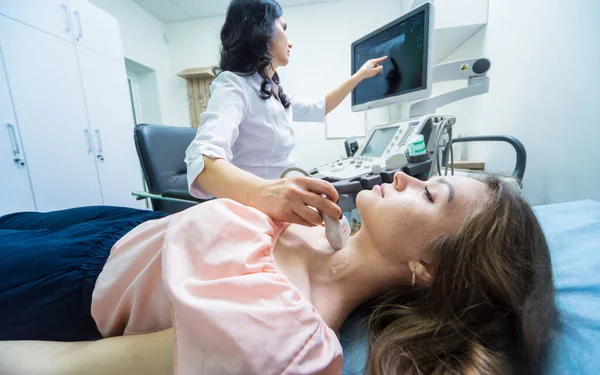 Médico usando ultra-som máquina de digitalização para examinar uma tireóide da mulher — Fotografia de Stock