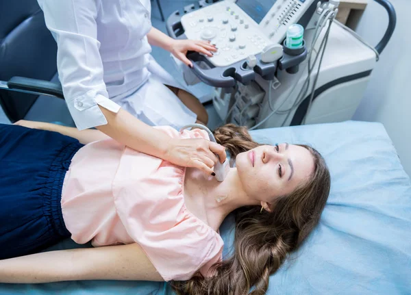 Medico che utilizza la macchina di scansione a ultrasuoni per esaminare una tiroide della donna — Foto Stock