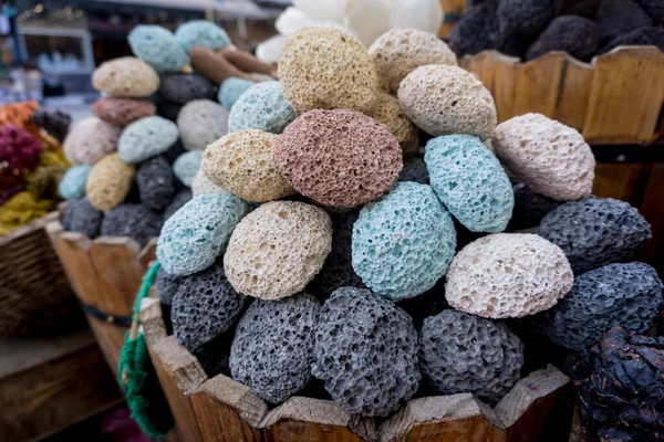 Colored pumice stones for foot care in the wooden baskets on the street market — Stock Photo, Image