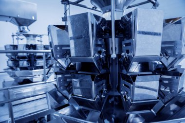 Bir fabrikada dikey çoklu başlı ambalaj makinesi atıştırmalıkları ve çipler