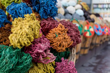 Dekoratif toplara dönüşmüş renkli kurumuş deniz yosunu sokak pazarındaki ahşap sepetlerde yatıyor.