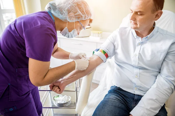 Медсестра приймає зразки крові пацієнтів у лабораторії — стокове фото