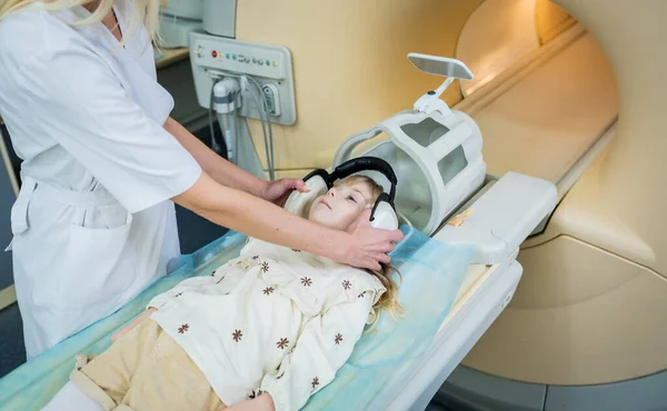 Radiologista prepara a menina para um exame cerebral MRI — Fotografia de Stock