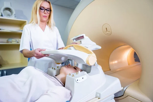 Радіолог готує молоду жінку до МРТ - обстеження мозку. — стокове фото