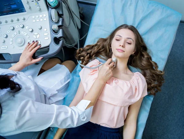 Az orvos ultrahangos letapogató gépet használ egy nő pajzsmirigyének vizsgálatához. — Stock Fotó