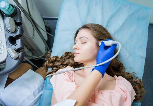 Доктор використовує ультразвукову скануючу машину для вивчення голови жінки — стокове фото