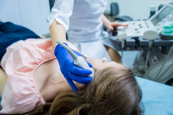 Bir kadının kafasını muayene etmek için ultrason cihazı kullanan bir doktor. — Stok fotoğraf