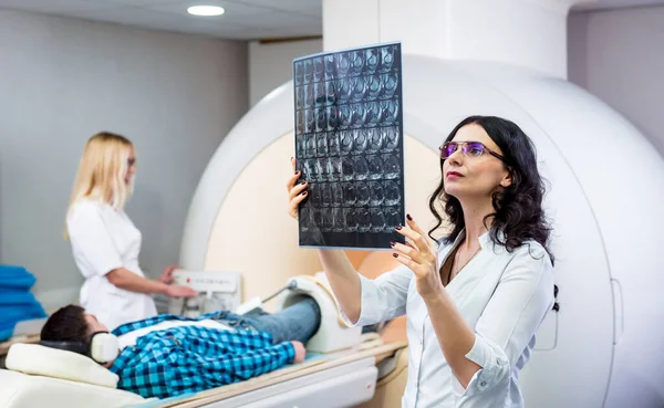 Radiólogo con un paciente masculino examinando una resonancia magnética — Foto de Stock