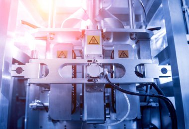 Bir fabrikada dikey çoklu başlı ambalaj makinesi atıştırmalıkları ve çipler