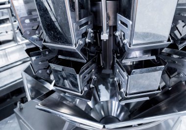 Bir fabrikada dikey çoklu başlı ambalaj makinesi atıştırmalıkları ve çipler