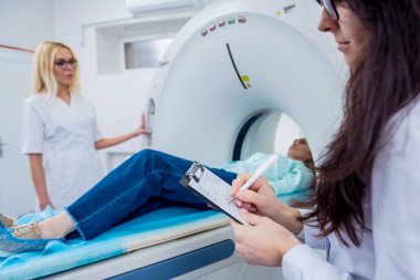 Doktorlar ve hasta hastanedeki bilgisayarlı tomografi odasında.