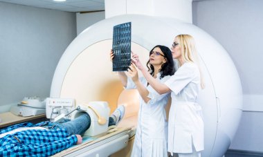 MR taraması yapan bir erkek hasta ile radyoloji uzmanı.