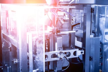 Bir fabrikada dikey çoklu başlı ambalaj makinesi atıştırmalıkları ve çipler