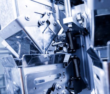 Bir fabrikada dikey çoklu başlı ambalaj makinesi atıştırmalıkları ve çipler