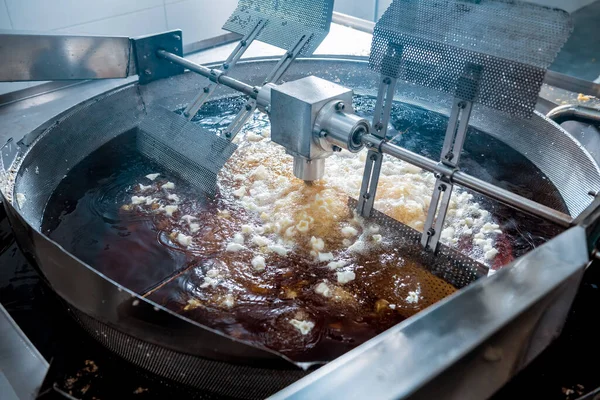 Conveyor line for frying snacks and chips in a modern factory