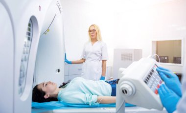 Radyolog, bilgisayarlı tomografi odasında bir kadın hasta ile birlikte.