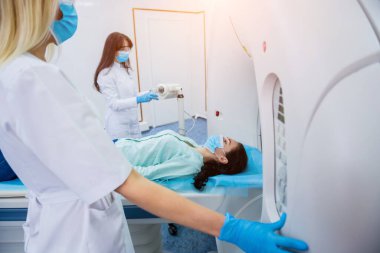 Radyolog, bilgisayarlı tomografi odasında bir kadın hasta ile birlikte.