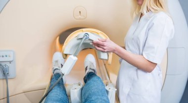 Radyoloji uzmanı hastayı MRI diz muayenesi için hazırlıyor.