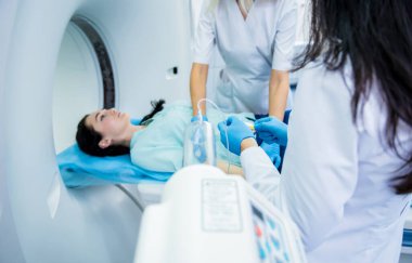 Radyolog, bilgisayarlı tomografi odasında bir kadın hasta ile birlikte.