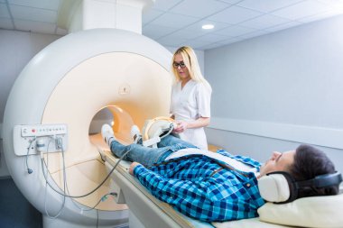 Radyoloji uzmanı hastayı MRI diz muayenesi için hazırlıyor.