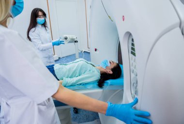 Radyolog, bilgisayarlı tomografi odasında bir kadın hasta ile birlikte.