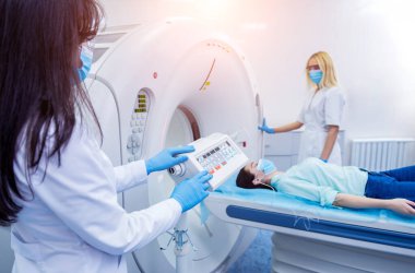 Radyolog, bilgisayarlı tomografi odasında bir kadın hasta ile birlikte.