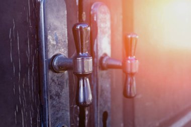 Tahta kahverengi kapılardaki metal kırsal kapı kolları.